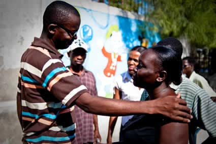 man and woman talking with people in the background