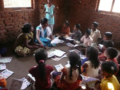 group of children sitting on floor writing letters