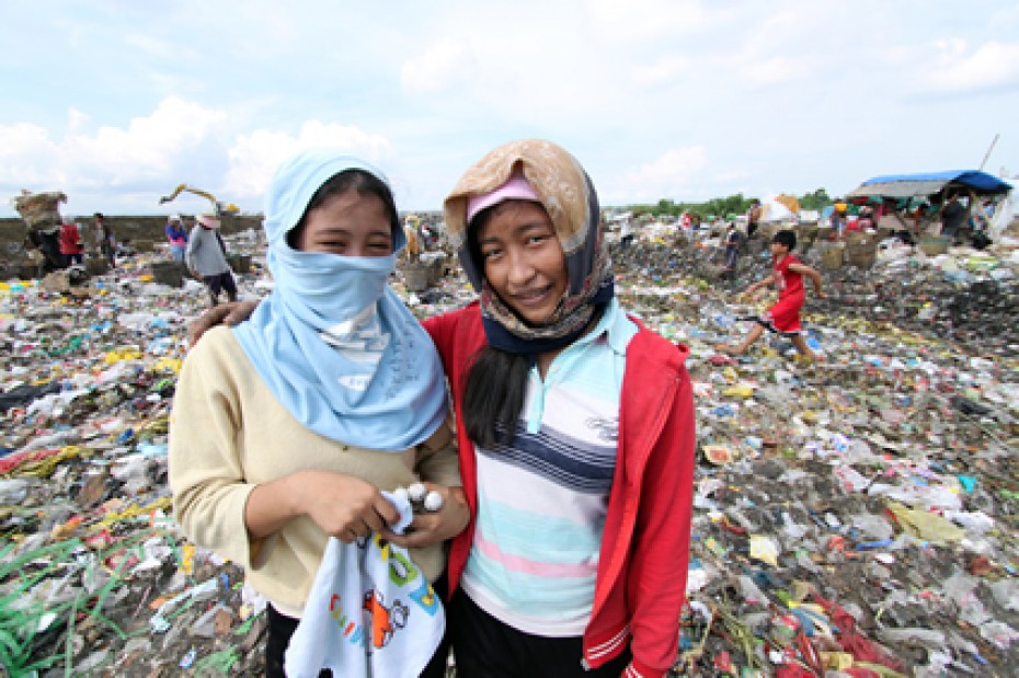 two women standing in garbage dump
