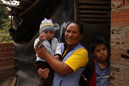 woman holding small child and standing next to a boy