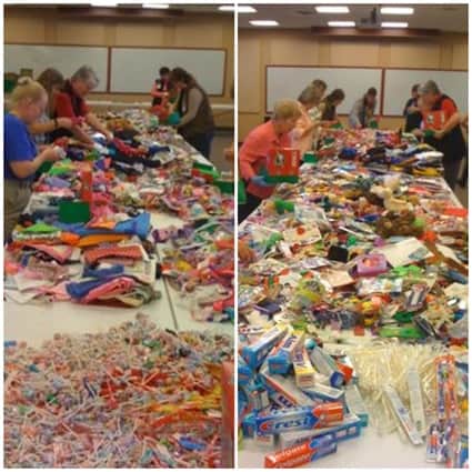 gathering of people packing Christmas shoeboxes