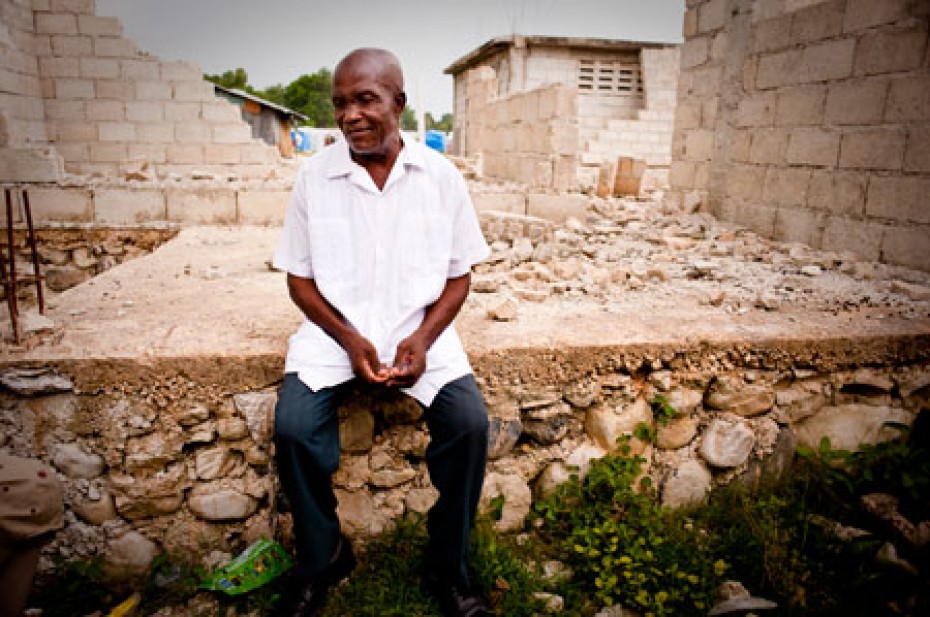 after-haiti-earthquake Haitian man sitting near damaged building