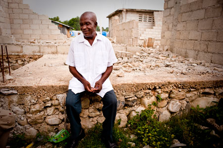 man sitting on floor of damaged home