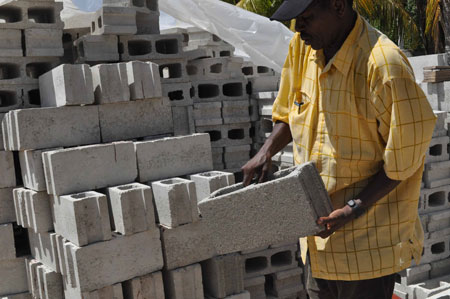 man next to stacks of cement blocks