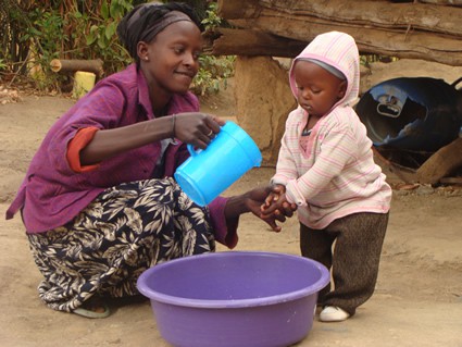 woman washing a small child's hands