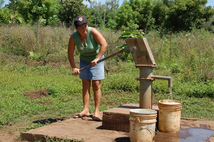 woman pumping water into buckets