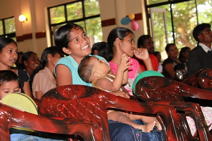 group of people gathered in church with some women holding babies