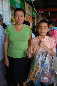 woman standing with boy holding gifts