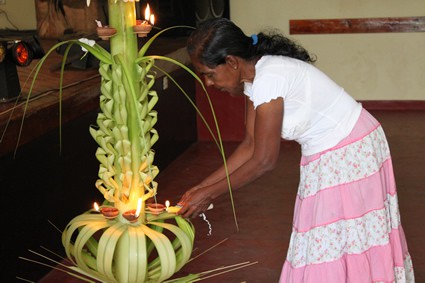 woman lighting candles on traditional display