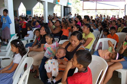 large group of adults and children sitting inside