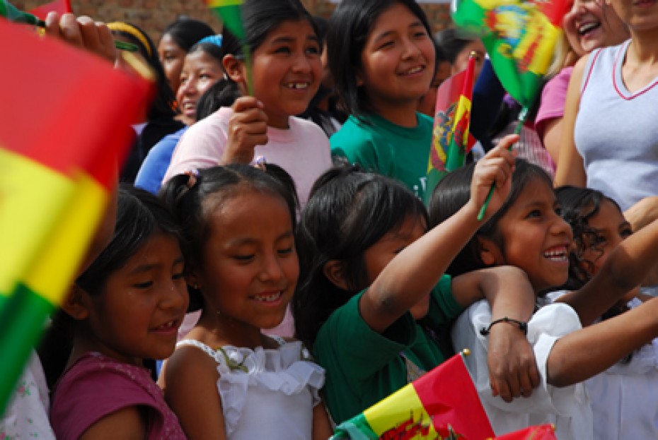 smiling children waving Bolivian flags