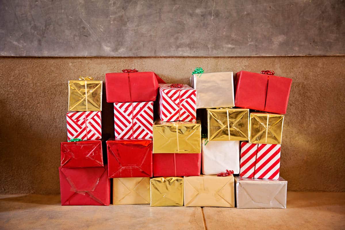 What Does the Bible Say About Giving? A stack of brightly colored presents sits against a wall