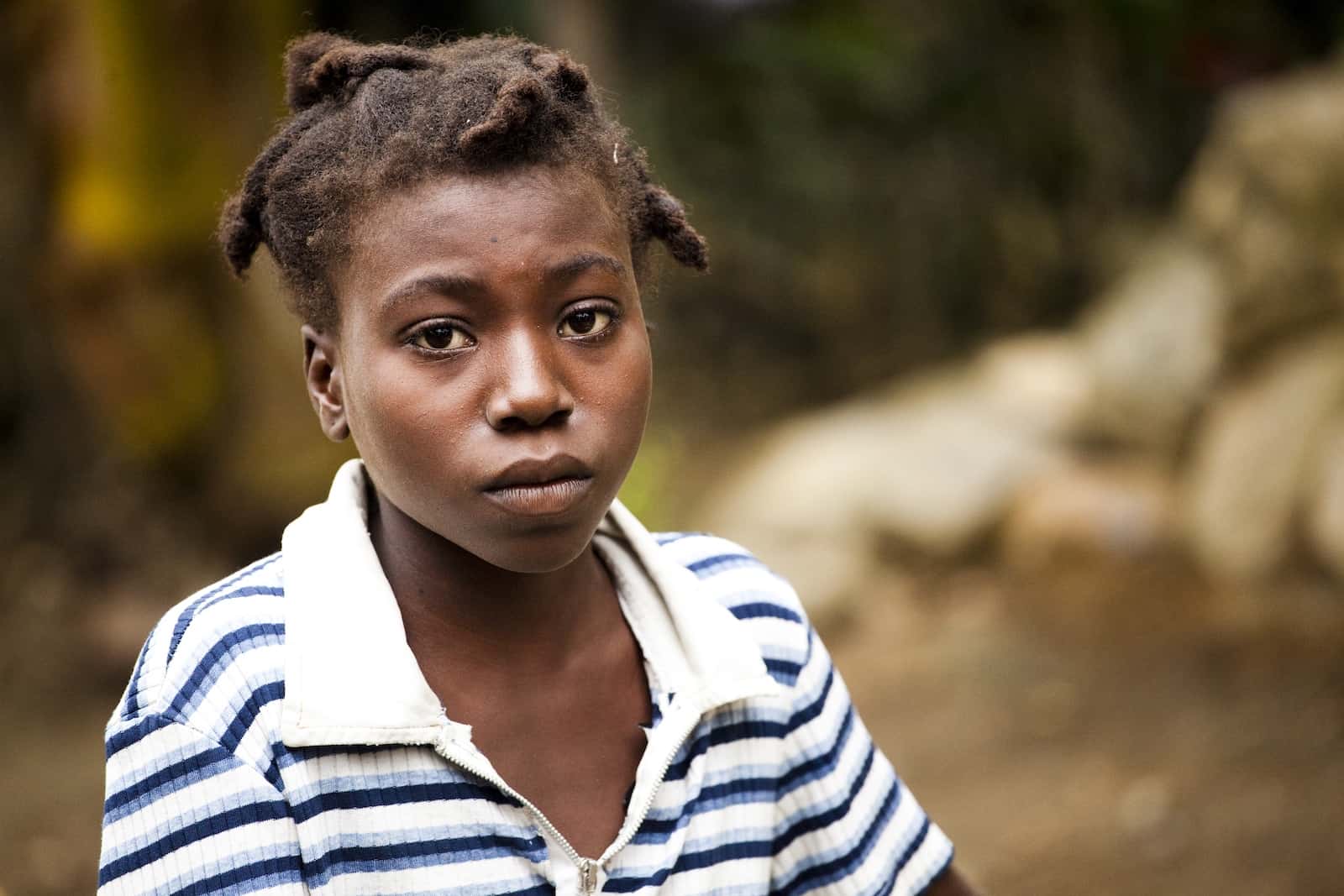 Brokenness Before God: A teenage girl sits, with a solemn look on her face, wearing a white and black striped shirt