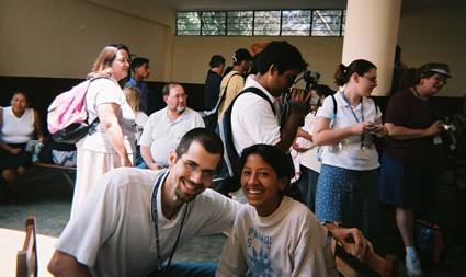 man and boy smiling for camera with several people in the background