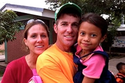 woman standing next to man holding a girl