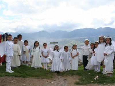 Children standing outside by a cross.