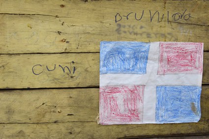 crayon drawing of Dominican flag posted on a wood wall