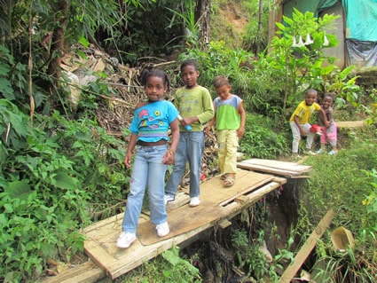 children walking on makeshift bridge