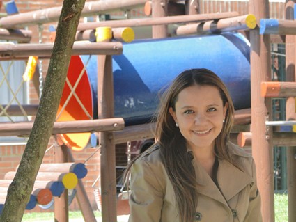 smiling woman standing in front of playground equipment