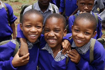 group of smiling boys in blue school uniforms