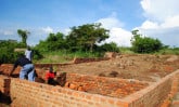 men building foundation with bricks