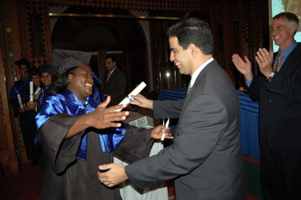 two men in suits congratulating graduates