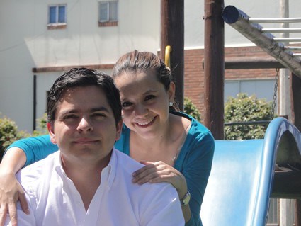 smiling woman with arms on shoulders of man in white shirt