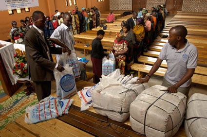 people in line to receive food baskets in a church