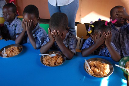 children praying before a meal
