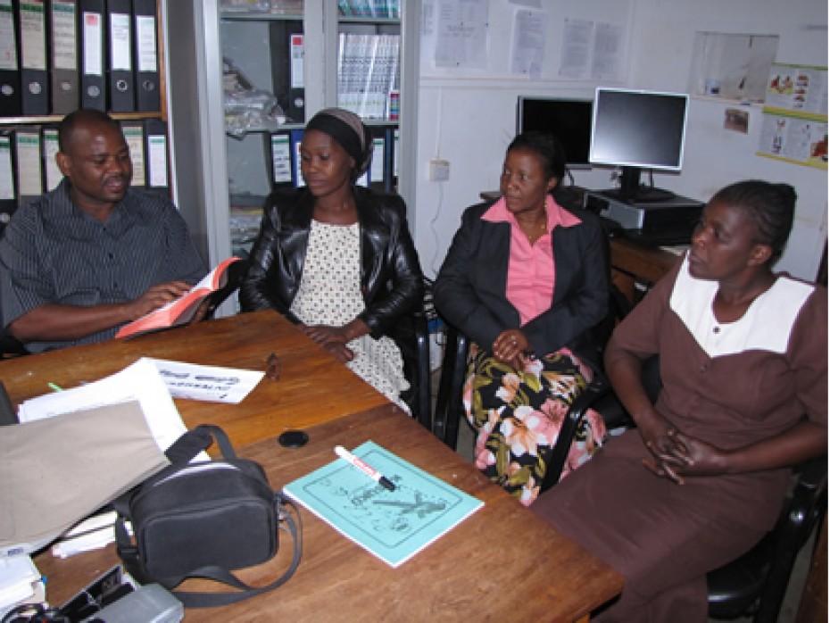 Three ladies and a man sitting in an office.