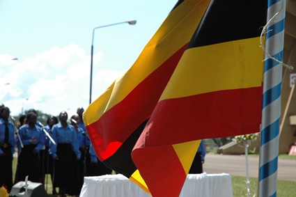 people standing in background of Ugandan flag