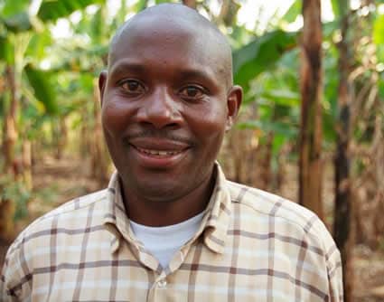 smiling man wearing brown plaid shirt