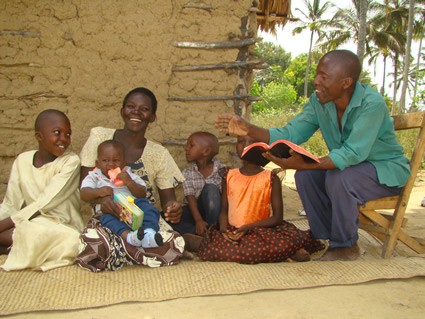 man reading to laughing woman and children