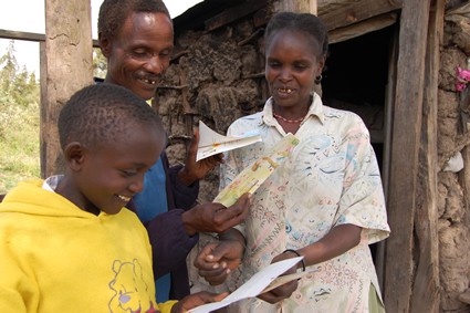 young girl reading letters with parents