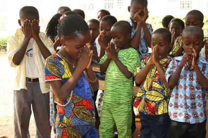 large group of children praying