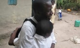 Older student hugging a younger student outside school for encouragement