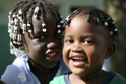 two smiling girls with beads in their hair