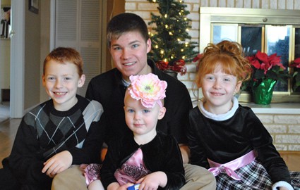 two boys and two girls posing for a family photo