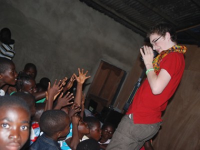 teen taking photos of a group of children