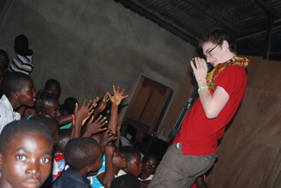 teen taking photos of a group of children