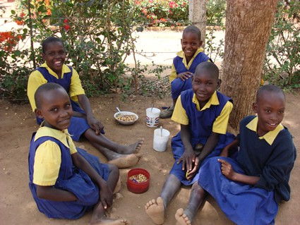 group of children in school uniforms enjoying a snack