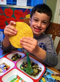 smiling boy holding tostado shells