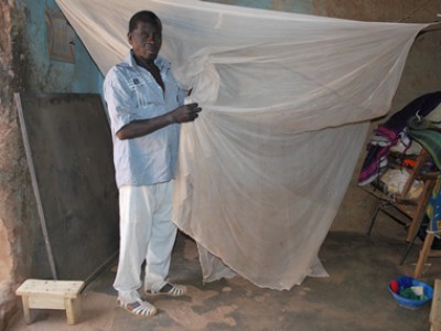 Man holding a mosquito net.