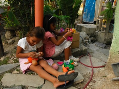 girls sitting outside playing with dolls