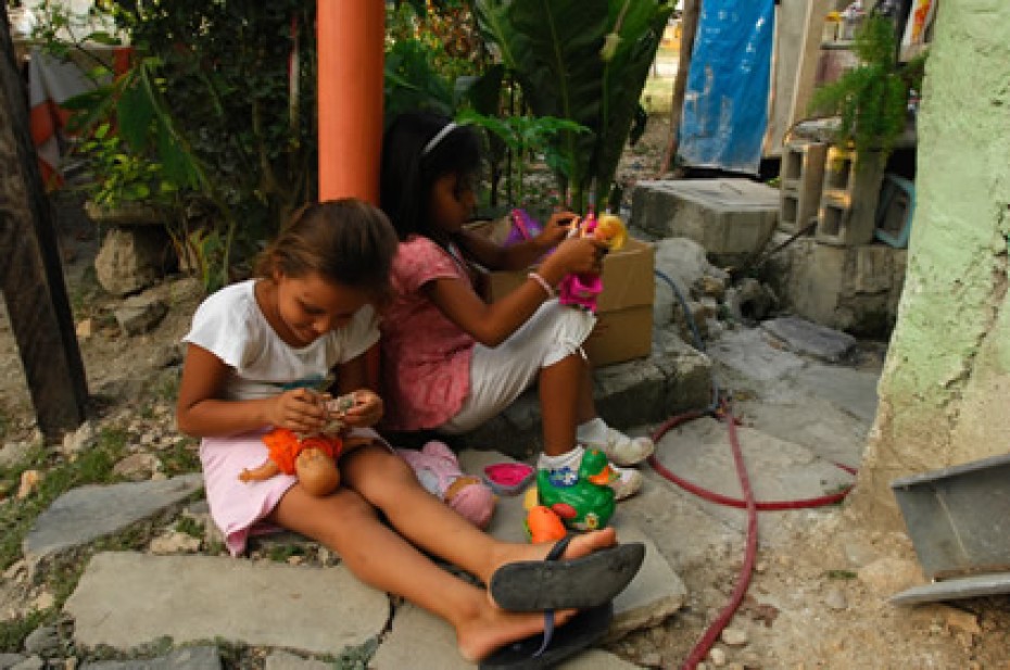 girls sitting outside playing with dolls