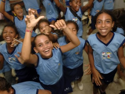 group of joyful smiling young people looking up at the camera in their blue shirts