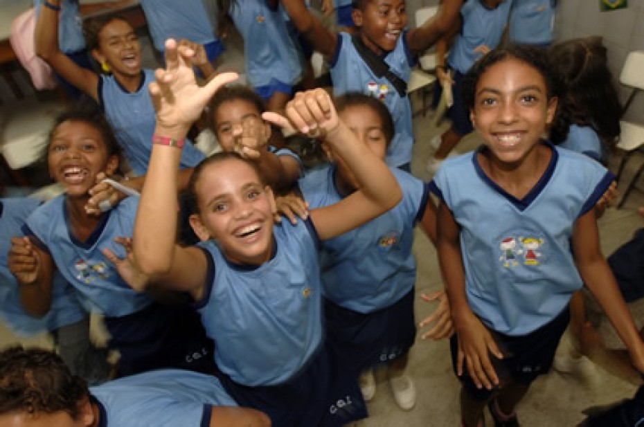 group of joyful smiling young people looking up at the camera in their blue shirts