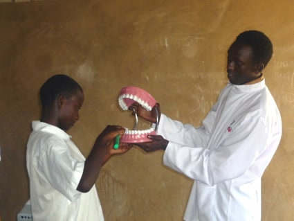 young man teaching a boy about dental hygiene