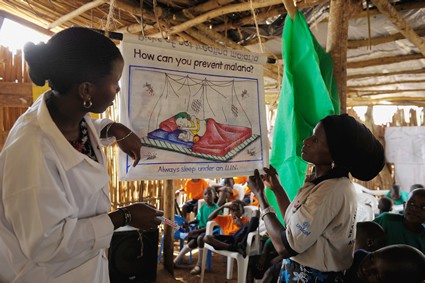 women teaching children about malaria