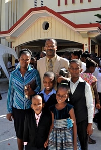 family of six with mom and dad standing with three boys and a girl